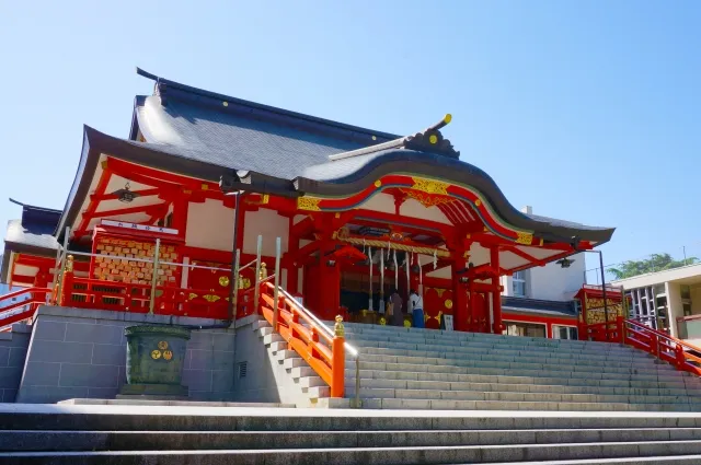 Vermilion main hall of Hanazono Shrine glowing in the sun
