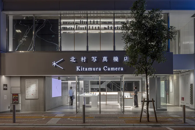 Modern glass storefront of Kitamura Camera in Shinjuku at night